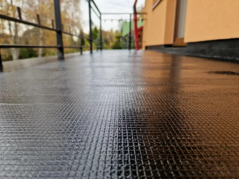Mokrý povrch tekuté hydroizolace na terase po aplikaci.