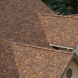 Detailní pohled na hnědé střechové šindele s viditelnými okapy.