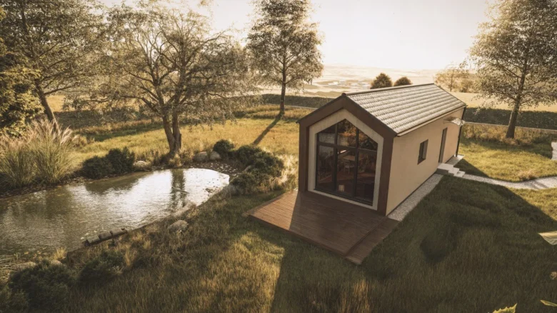 Moderní dřevostavba bungalov s velkým oknem u jezírka v přírodě.