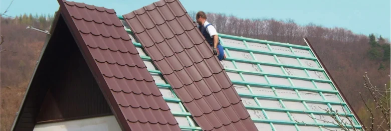 Montáž střechy s keramickou taškou na skloněném opláštění.