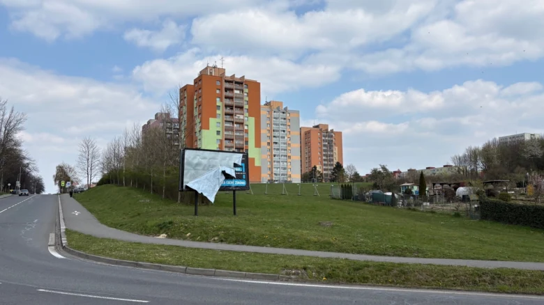 Barevné panelové domy v ostravské čtvrti s trávníkem a silnicí.
