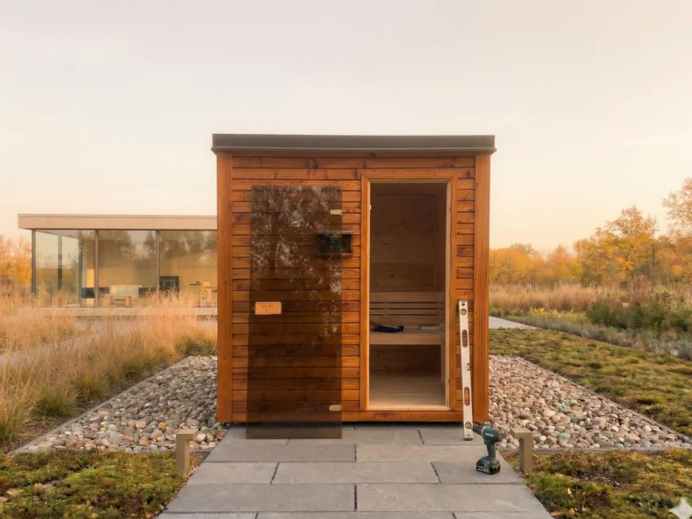 Dřevěná sauna ve fázi stavby s nástroji a úrovní.