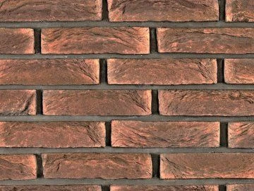 Detailní pohled na cihlový obklad stěny s viditelnými spárami.