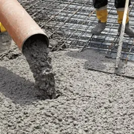 Zalévání betonu do potěru s výztuží na staveništi.