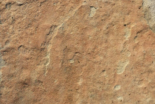Detailní záběr na texturu pískovce jako stavebního materiálu.
