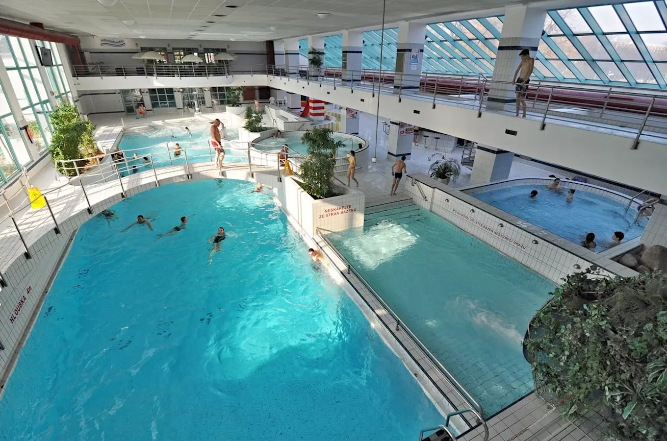 Vnitřní plavecký bazén s více hladinami pro sport i relaxaci.