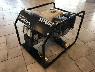 Černá benzínová elektrocentrála značky Honda na dlažbě.