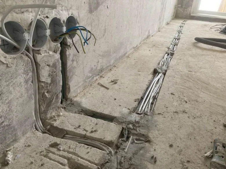 Elektroinstalace v bytě při rekonstrukci s viditelnými kabely.