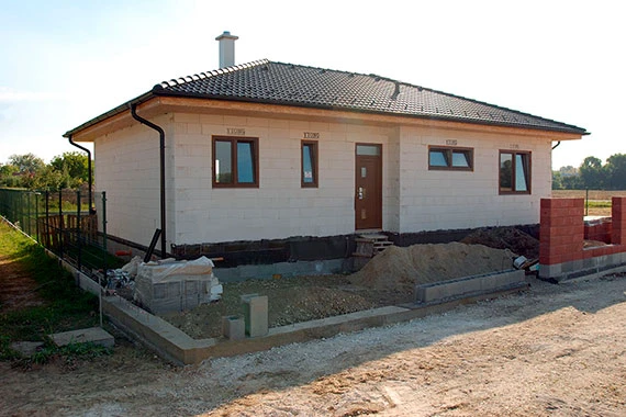 Rodinný dům z porobetonu ve fázi stavby s viditelnými zdmi.