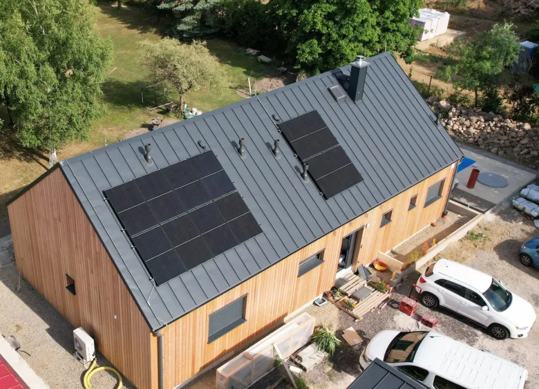 Dům s fotovoltaickými panely na střeše pro solární elektrárnu.