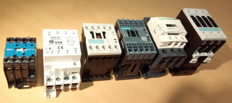 Řada průmyslových stykačů různých výrobců na neutrálním pozadí.