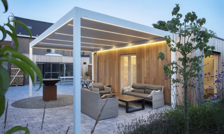 Moderní bílá pergola s osvětlením u domu se zahradním nábytkem.