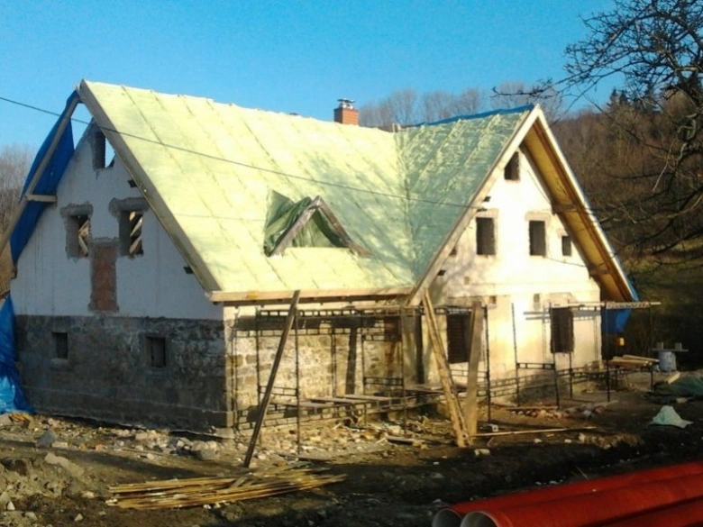 Starý dům s novou izolací na střeše během rekonstrukce.