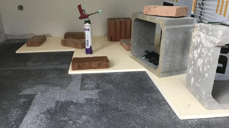 Příprava betonové podlahy s cihlami, pěnou a bloky pro leštění.