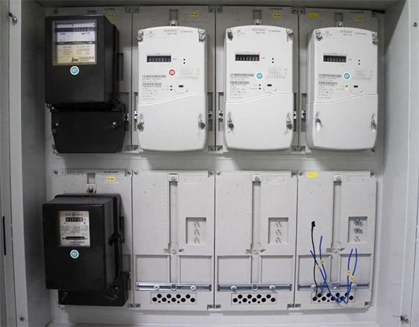 Elektrické měřiče v rozvaděči s viditelným zapojením a kabely.