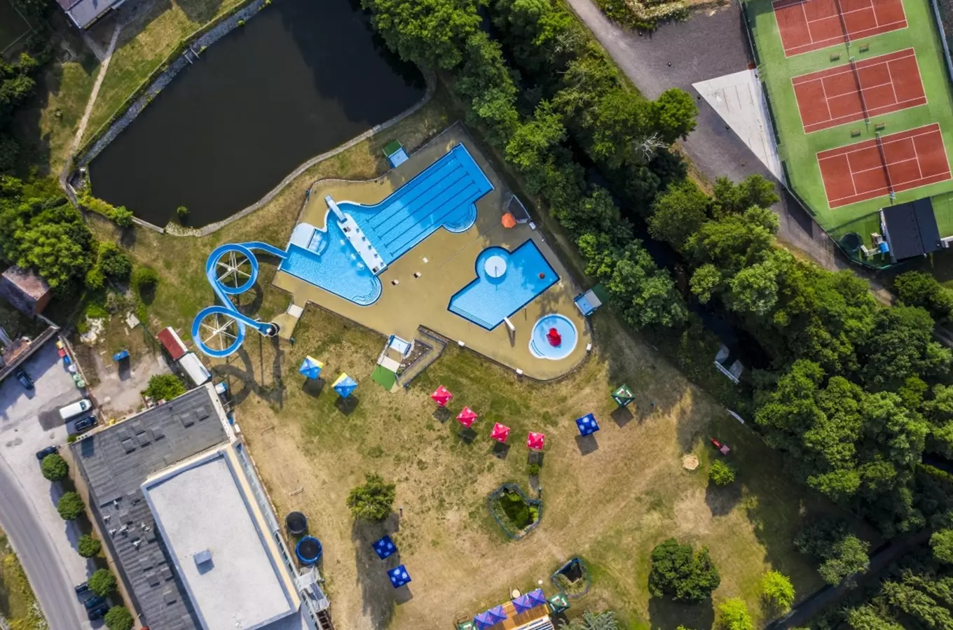 Záběr z dronu na koupaliště s bazény a vodními skluzavkami v Horovicích.
