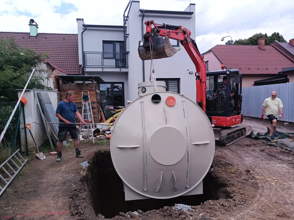 Instalace septiku na pozemku pomocí výkopového stroje.
