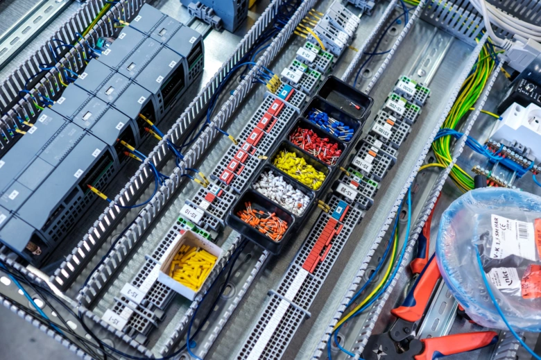 Průmyslová elektroinstalace s uspořádanými kabely a terminály v rozvaděči.