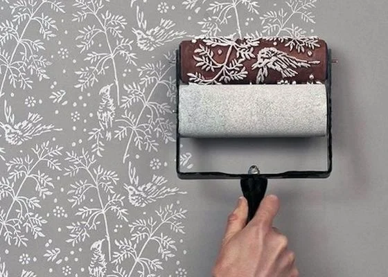 Ručník s rolí aplikuje bílý tapetový vzor na stěnu.