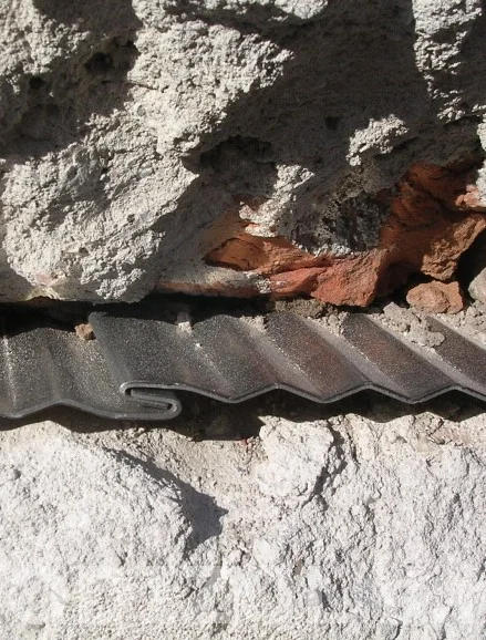 Detail podřezu zdiva s hydroizolační fólií mezi dvěma stěnami.
