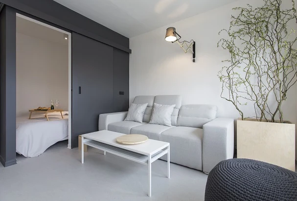 Moderní interiér s tmavě šedými zasouvacími dveřmi do ložnice.