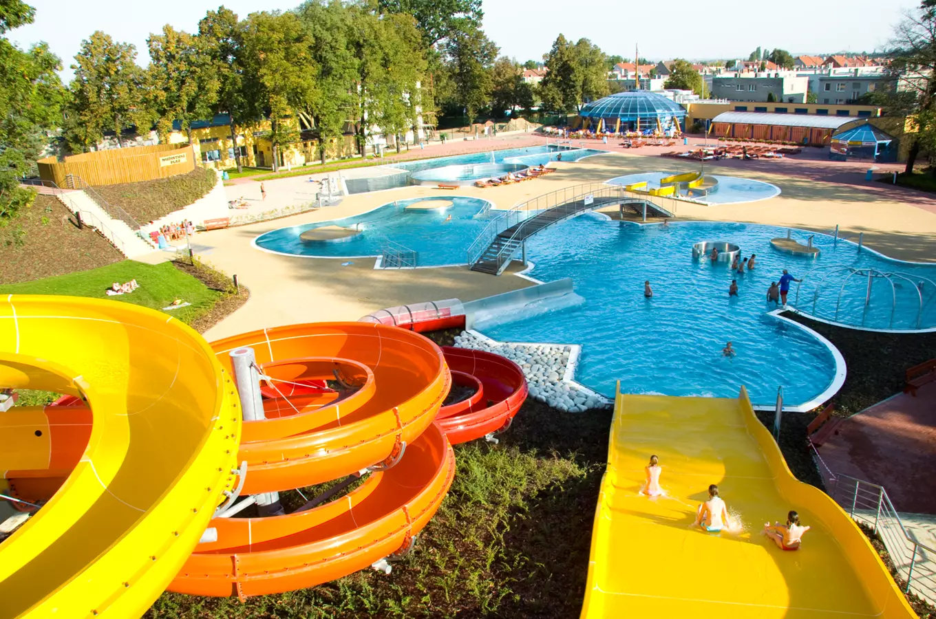 Venkovní akvapark s barevnými skluzavkami a bazény v Prostějově.