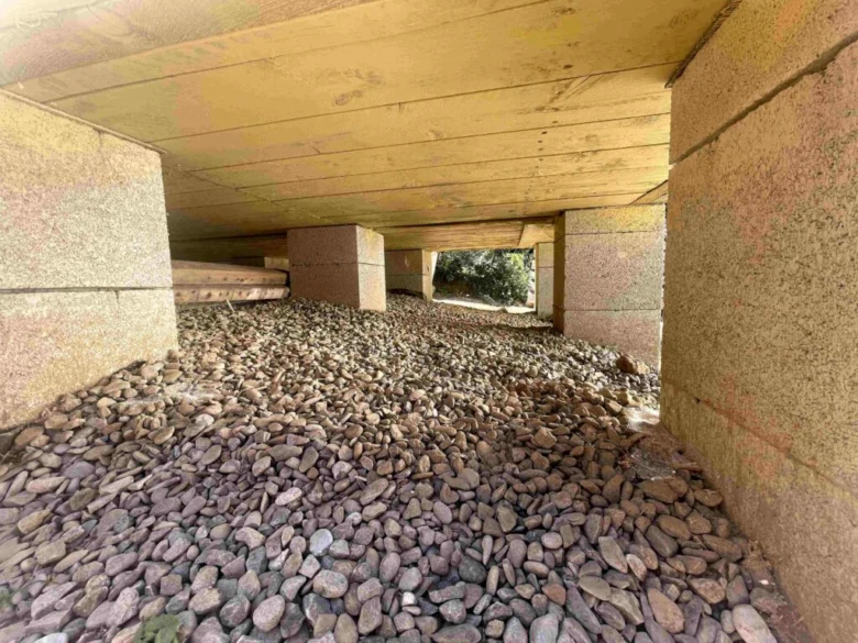 Konkrétní betonové patky pod dřevostavbou na štěrkovém loži.