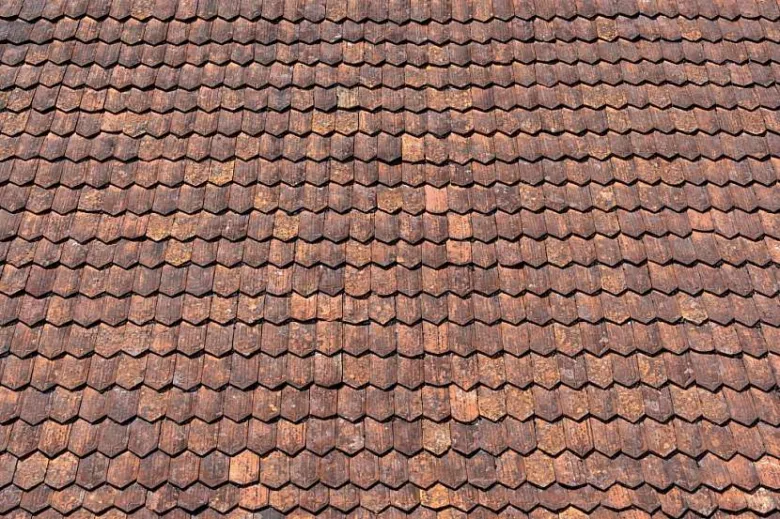 Detailní pohled na červenohnědé keramické střešní tašky.