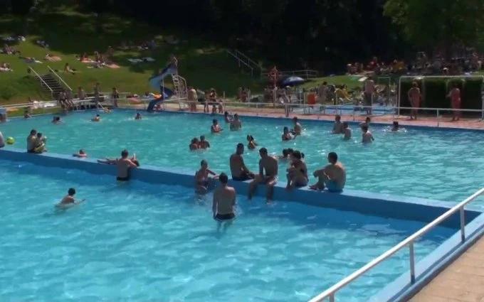 Lidé plavou a odpočívají na bazénu v Divoké Šárce.