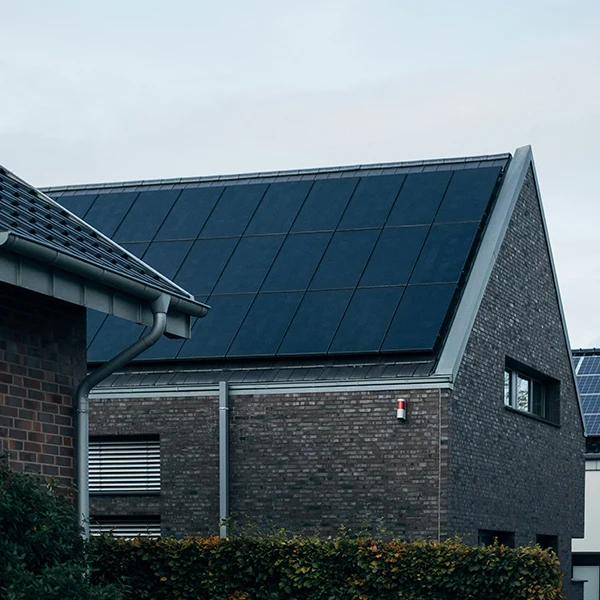 Moderní dům s fotovoltaickými panely na střeše.