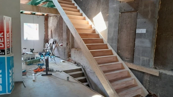 Nově vyrobené dřevěné schodiště v interiéru během stavebních prací.