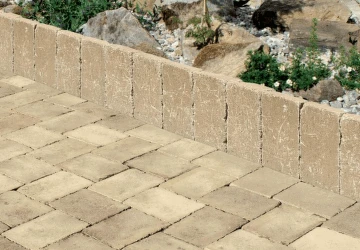 Nainstalované betonové obrubníky vedle dlažby v zahradě.