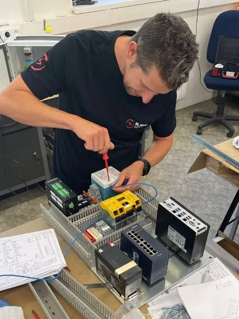 Technik sestavuje elektrický rozvaděč s moduly v dílně.