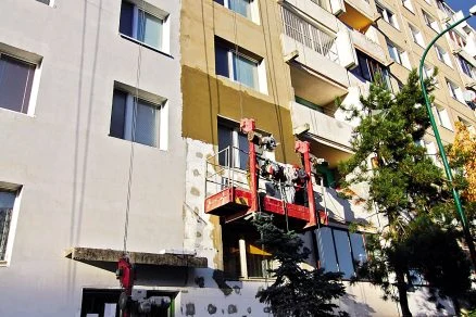 Práce na fasádě s použitím polystyrenu u bytového domu.