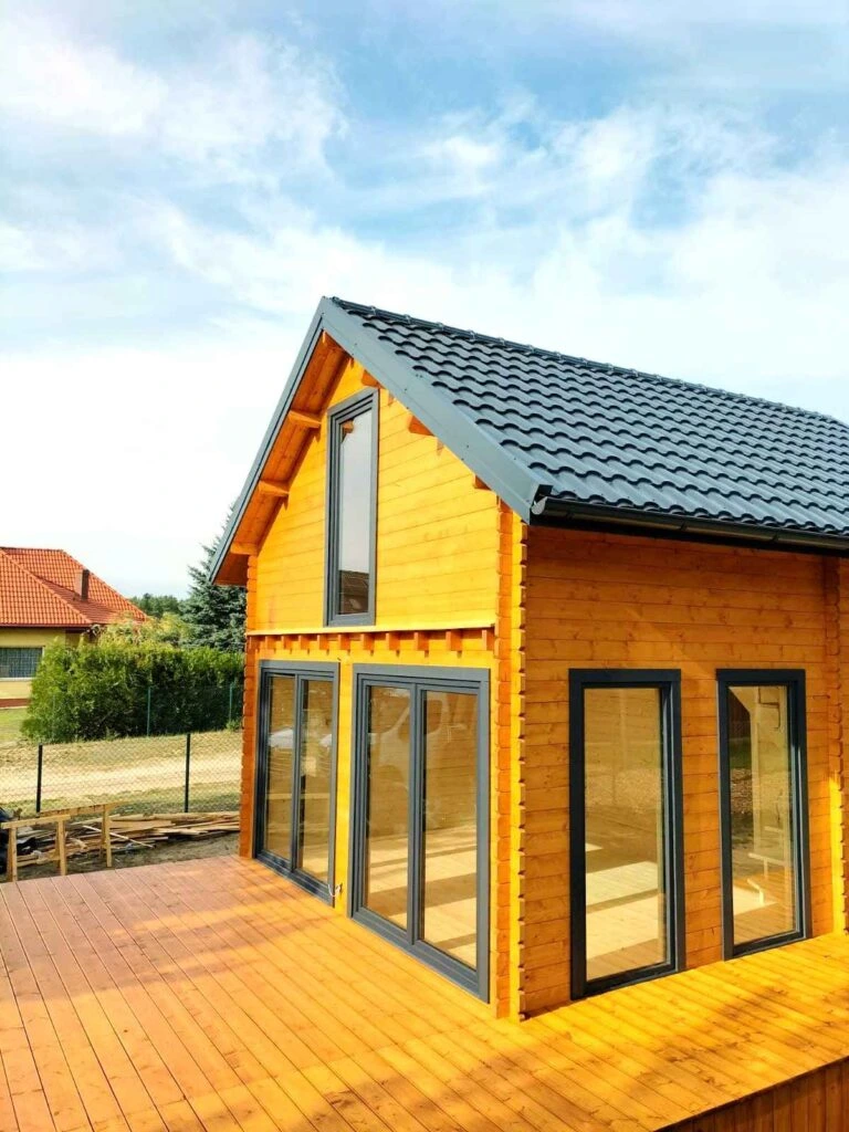 Dřevěná chata s velkými okny pro celoroční bydlení.