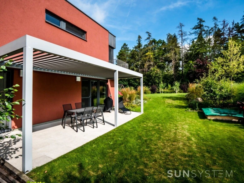 Bioklimatická pergola s venkovním posezením u domu.