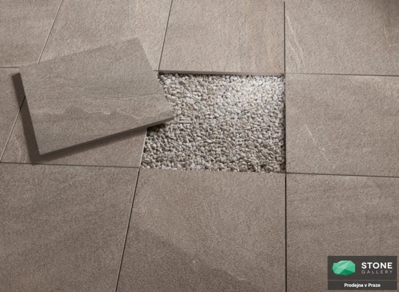 Detailní pohled na dlažbu s odhalenými kamínky pod povrchem