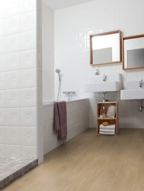 Moderní koupelna s vanou, umyvadly a dřevěným podlahovým materiálem.