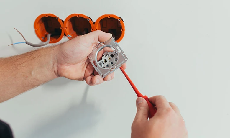 Instalace elektrické zásuvky do oranžového boxu na stěnu.