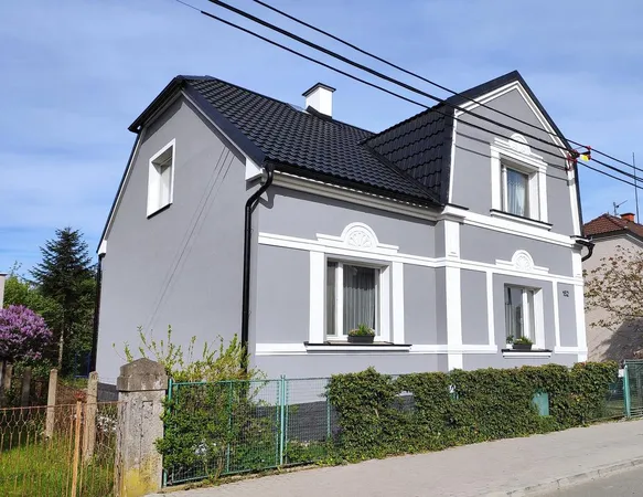 Modernizovaná fasáda domu po rekonstrukci s novou střechou.