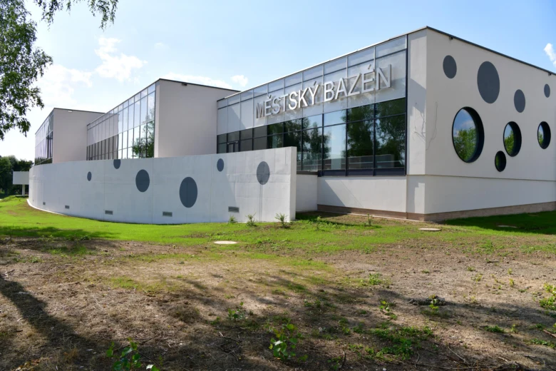 Moderní krytý městský bazén v Karviné s kruhovými okny.
