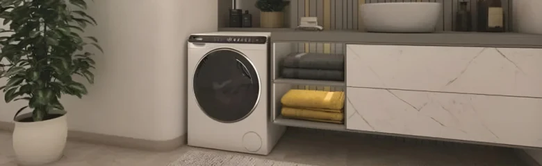Malá pračka v koupelně pod umyvadlem s žlutými utěrky.