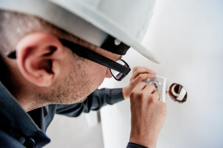 Elektrikář montuje vypínač světla do zdi v interiéru.