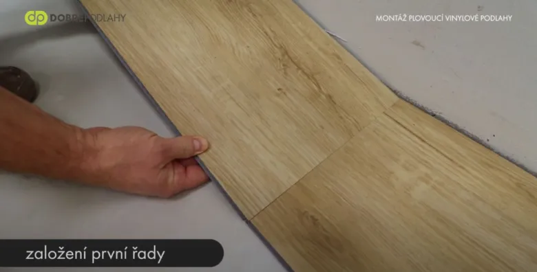Ruční pokládka první řady plovoucí vinylové podlahy.