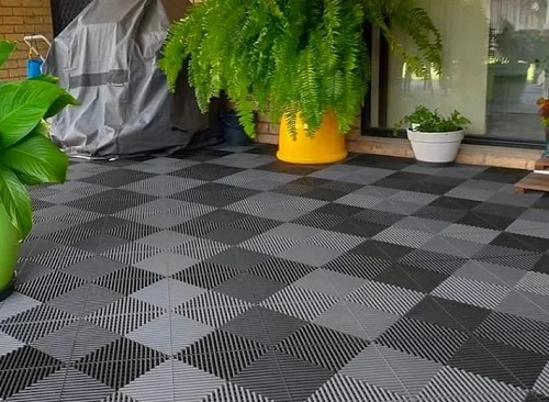 Sedací dlaždice na balkoně z plastu v šedé barvě.