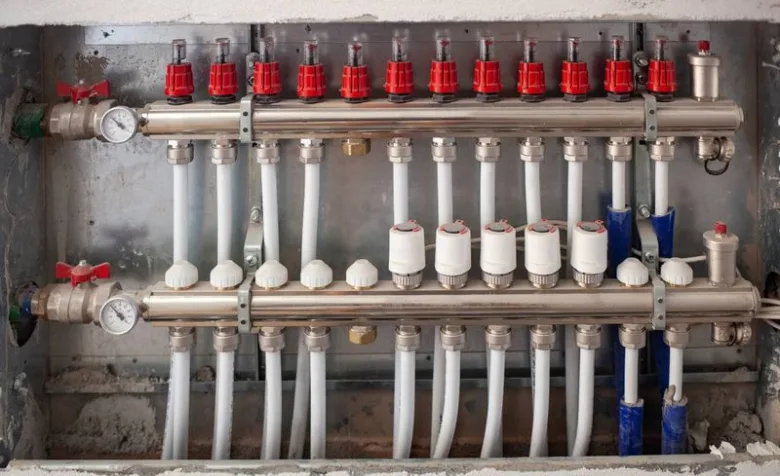 Instalace rozdělovače pro podlahové topení s vývody do potrubí.
