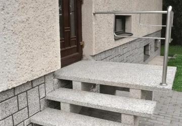 Betonové venkovní schody vedoucí k vchodu do domu.