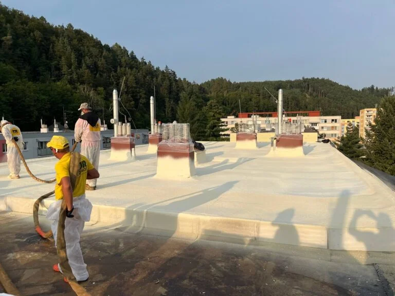 Práce na tepelné izolaci střechy pomocí pěnového materiálu.