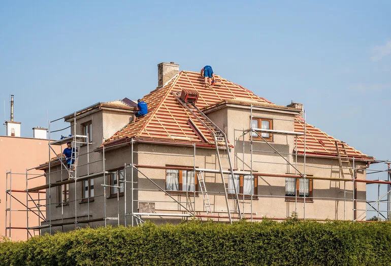 Práce na rekonstrukci střechy domu s lešení.