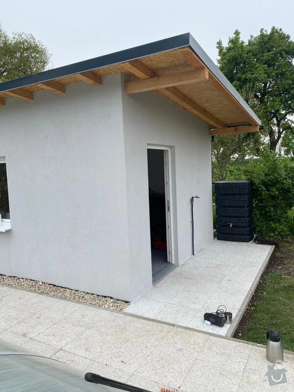 Nezhotovený zahradní domek s bílou fasádou a dřevěným stropem.